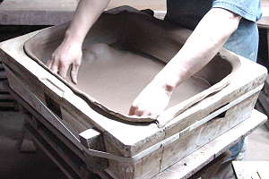 Herstellung handgemachter Bonsaischalen - Der knetfähige Ton wird in die Gipsform gedrückt