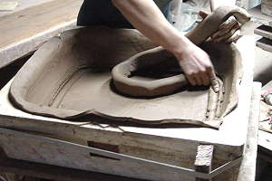 Herstellung handgemachter Bonsaischalen - Der knetfähige Ton wird in die Gipsform gedrückt