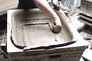 Production de pots à bonsaï faits à la main - L'argile malléable est pressée dans le moule en plâtre